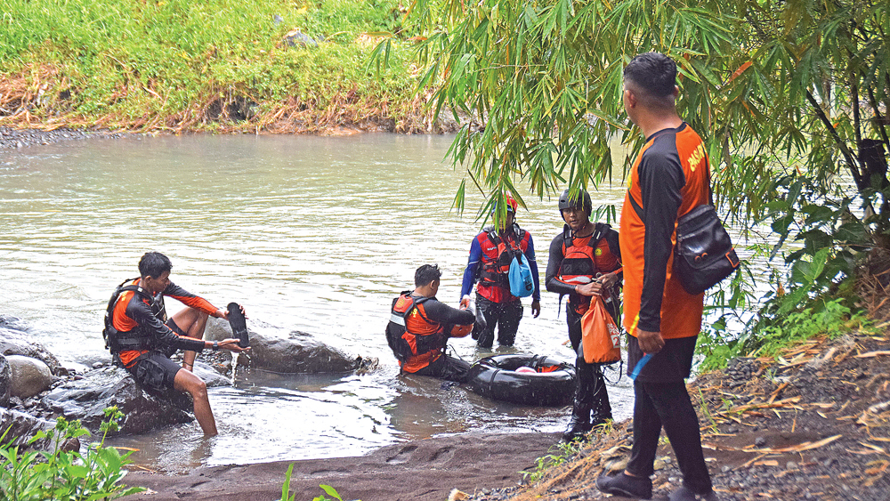 Petugas gabungan melakukan pencarian korban yang diduga hanyut di sungai Kemapag, Dusun Kumbo, Desa Gumirih, Kecamatan Singojuruh, Jumat (9/1).