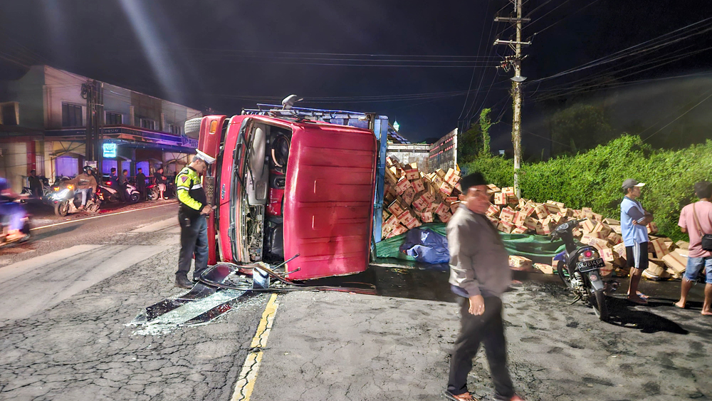 MUATAN TUMPAH: Truk bermuatan minyak goreng tujuan Lombok terguling di jalan raya Desa Ketapang, Kecamatan Kalipuro, Kamis (8/1).