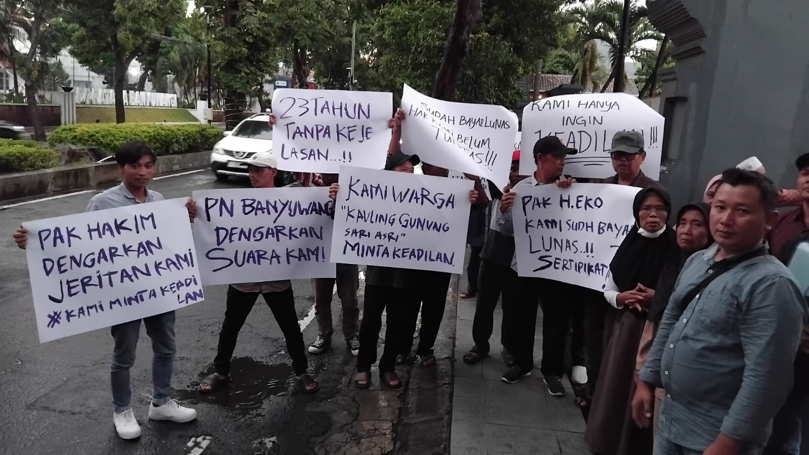 BEBER POSTER: Sejumlah warga pembeli tanah kavling Gunungsari Asri menggelar aksi di depan PN Banyuwangi, Jumat (9/1).