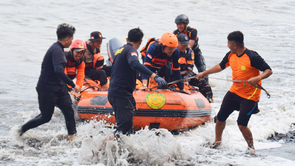 Petugas gabungan melakukan pencarian korban yang hanyut di Sungai Kemapag, kawasan Pantai Bomo, Kecamatan Blimbingsari, Sabtu (10/1).