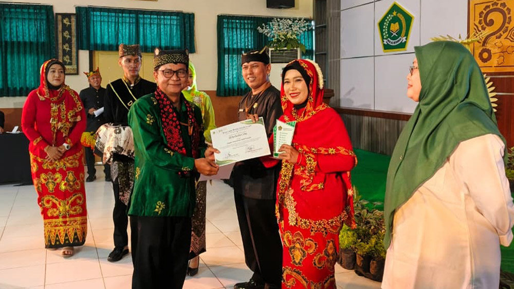 Kepala Kemenag Banyuwangi Chaironi Hidayat menyerahkan penghargaan di aula MAN 1 Banyuwangi, Senin (12/1).