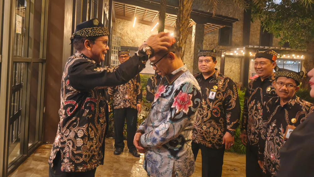 Kepala Kemenag Banyuwangi Chaironi Hidayat memasangkan udeng kepada Kepala Kemenag Jatim Akhmad Sruji Bahtiar di Hedon Estate, Rabu malam (14/1).