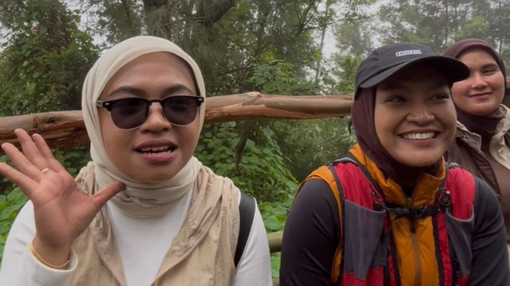 Nur Fitri Buamona wisatawan asal Ternate, Maluku Utara, beristirahat saat mendaki Kawah Ijen Banyuwangi.