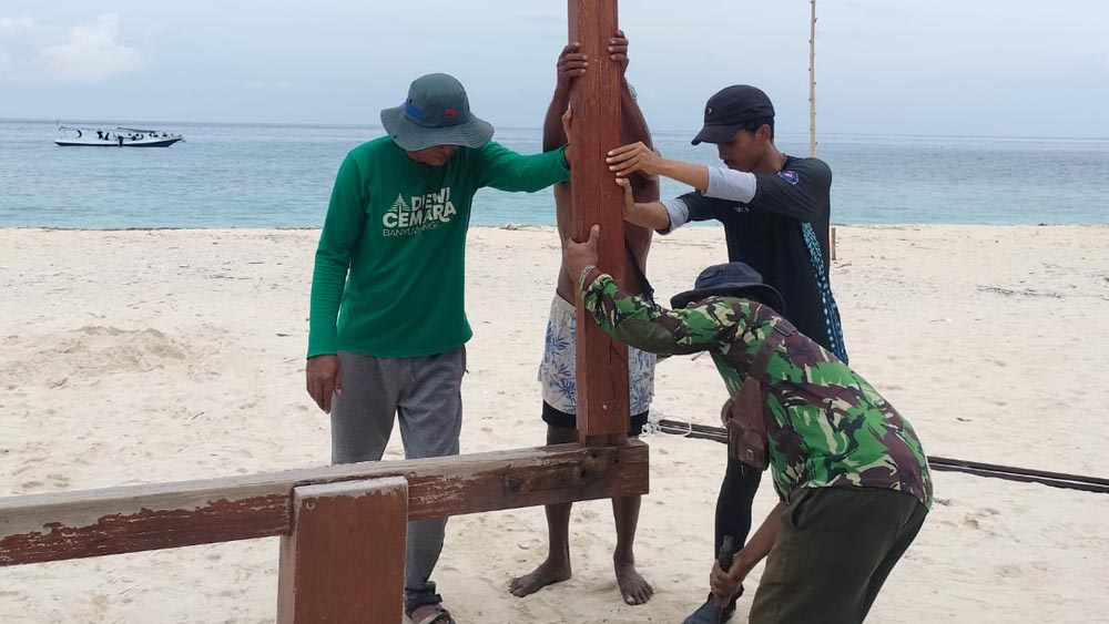 SWADAYA: Sejumlah anggota Pokdarwis Grand Watudodol bersama mahasiswa memperbaiki papan penanda di Pulau Tabuhan, Sabtu  (24/1).