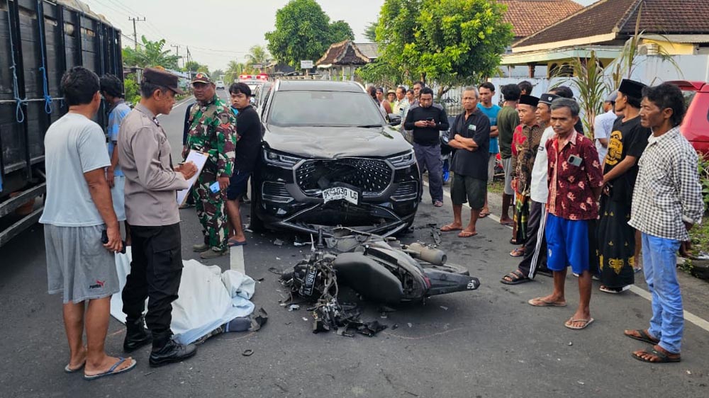 OLAH TKP: Anggota Polsek Bangorejo Aiptu Sudjatmiko sedang melakukan identifikasi pada korban laka lantas di Jalan Raya Dusun Kedungrejo, Desa Sambimulyo, Kecamatan Bangorejo, Minggu (25/1).