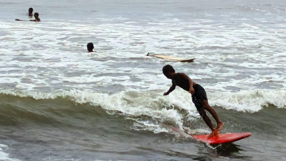 BERDIRI: Seorang anak terlihat lihai bermain selancar di Pantai Grajagan, Kecamatan Purwoharjo, Minggu (25/1).