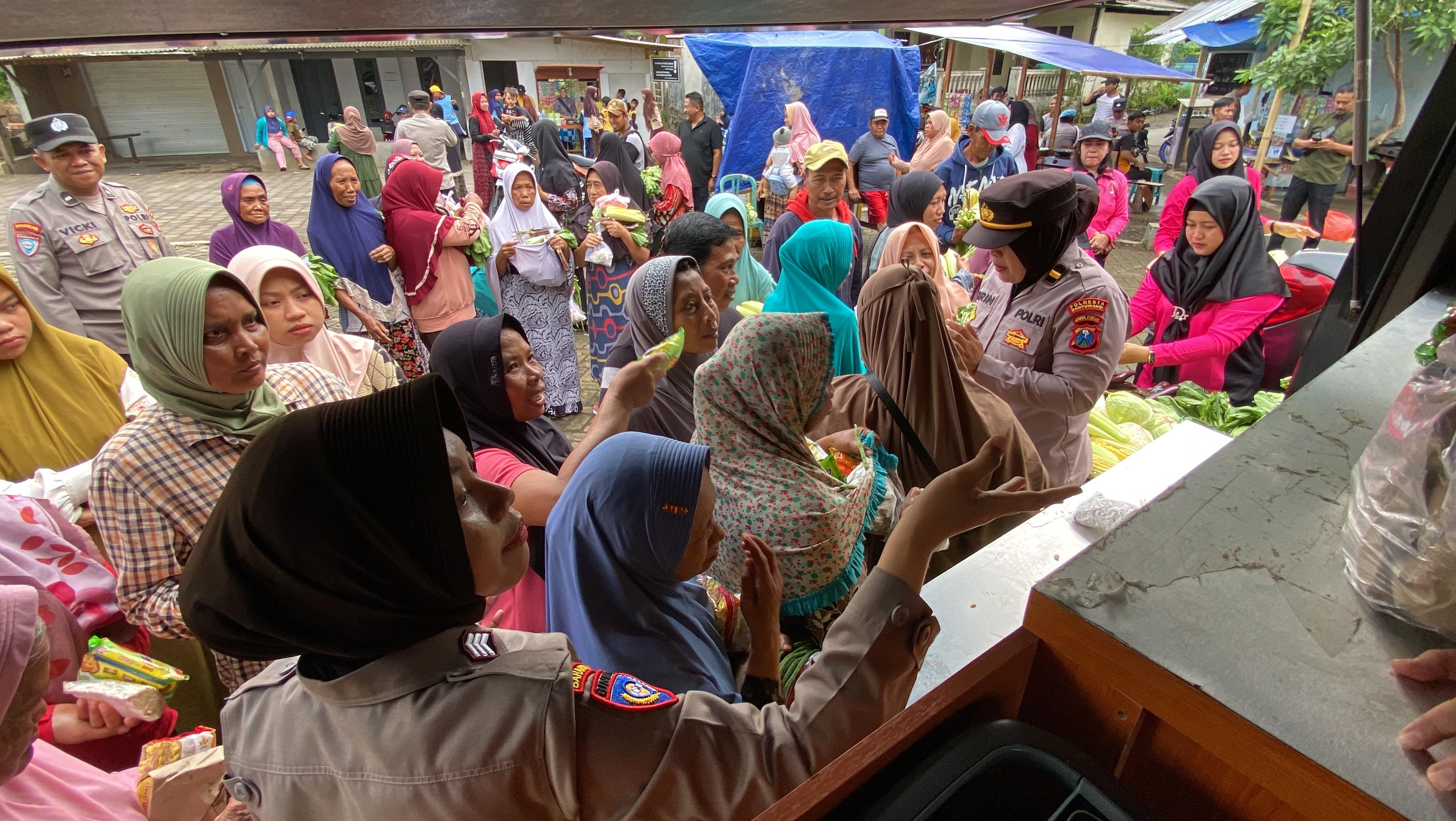 LARIS MANIS: Warga berebut sayuran gratis yang dibagikan personel Satuan Binmas Polresta Banyuwangi.