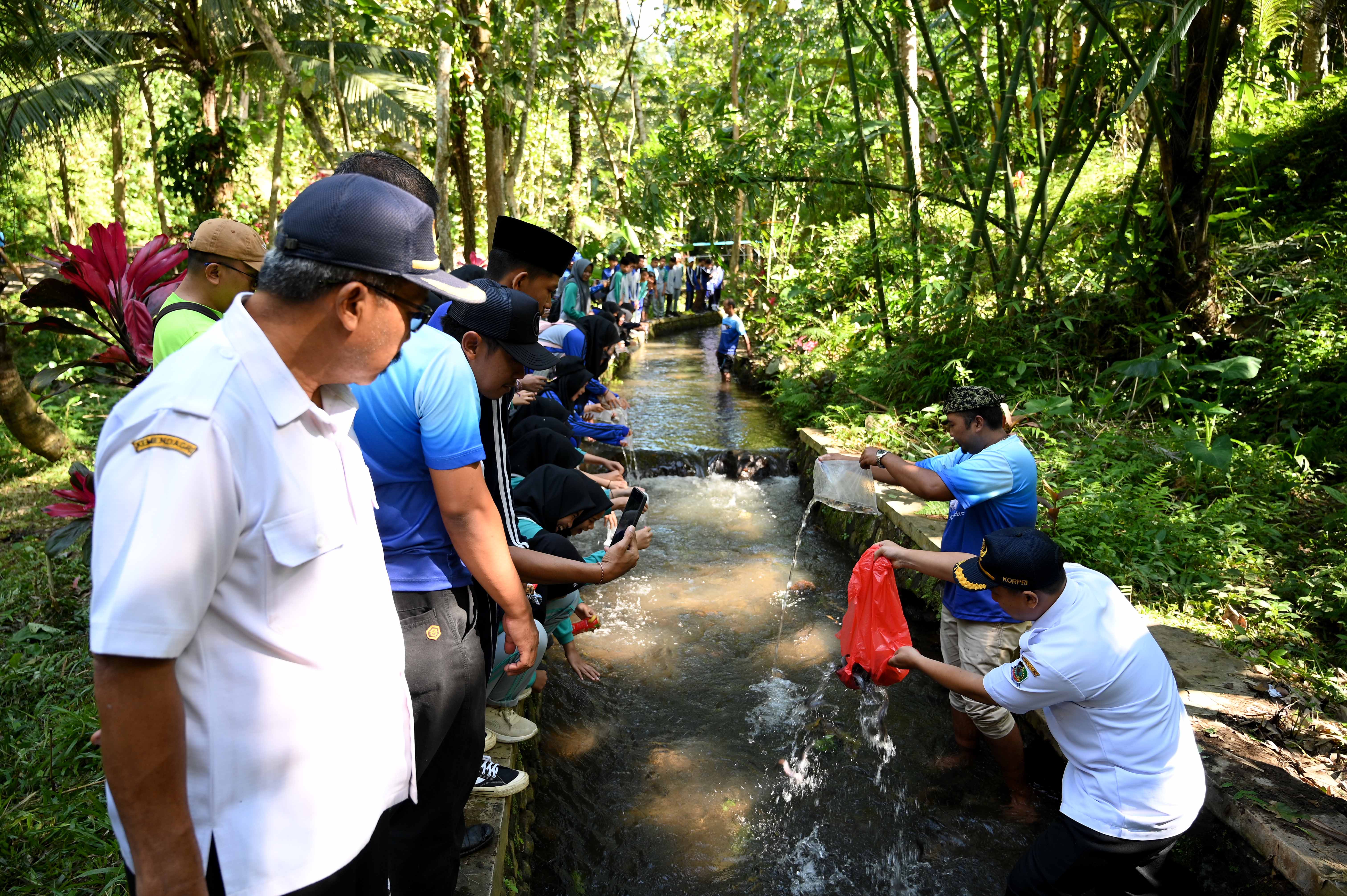 PELESTARIAN: Ratusan siswa bersama petugas Dinas PU Pengairan menebar bibit ikan dalam rangkaian program Sekardadu di Sungai Patemon, Desa Kelir pada Agustus 2025 lalu.