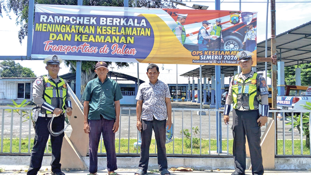 SOSIALISASI: Personel Satlantas Polresta Banyuwangi memasang banner imbauan Operasi Keselamatan Semeru 2026 di Terminal Brawijaya Banyuwangi, Minggu (1/2).