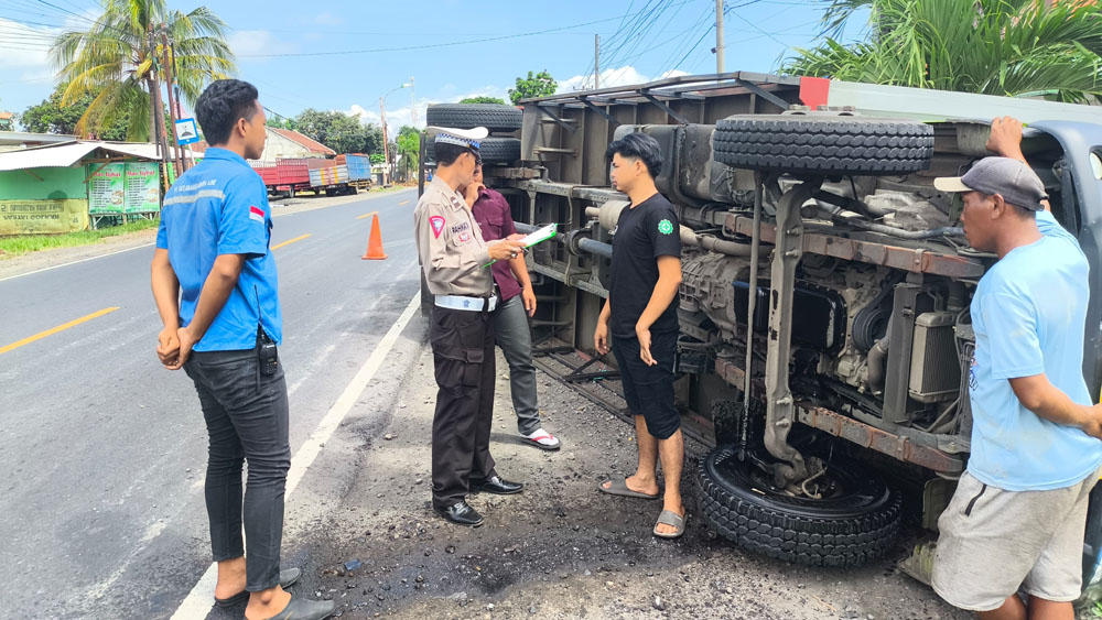SOPIR SELAMAT: Truk box bernomor polisi B 9434 SXW terguling di jalan raya Desa Bengkak, Kecamatan Wongsorejo, Selasa (3/2).