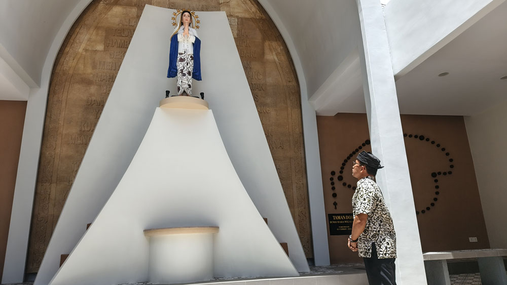 Romo Andreas Adhi Prasetyo memandangi patung Bunda Maria Berkebaya Gajah Oling di halaman gereja Katolik Paroki Maria Ratu Damai Banyuwangi, Rabu (4/2).
