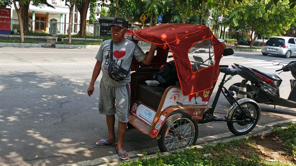 SEPI PENUMPANG: Dua pengayuh becak listrik Jamal dan Hadri  menunggu penumpang seharian di depan kantor Kecamatan Banyuwangi, Jumat (6/1).