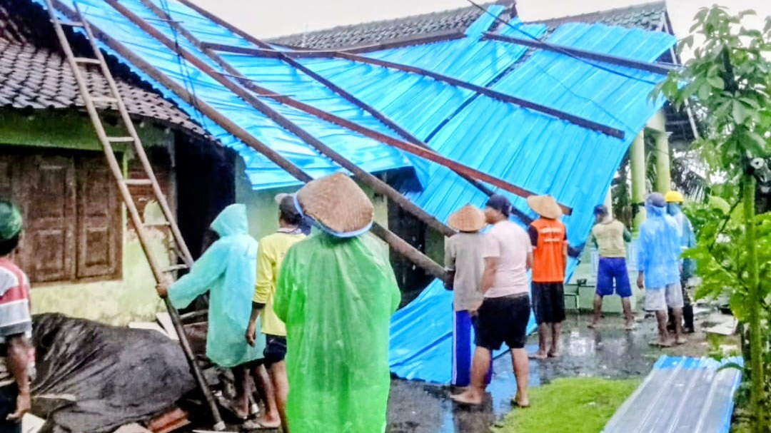 MELAYANG: Atap rumah milik Ngadenan, warga Desa Tambakrejo, Kecamatan Muncar terbang mengenai rumah tetangganya usai terkena angin kencang pada Sabtu (7/2) sore.