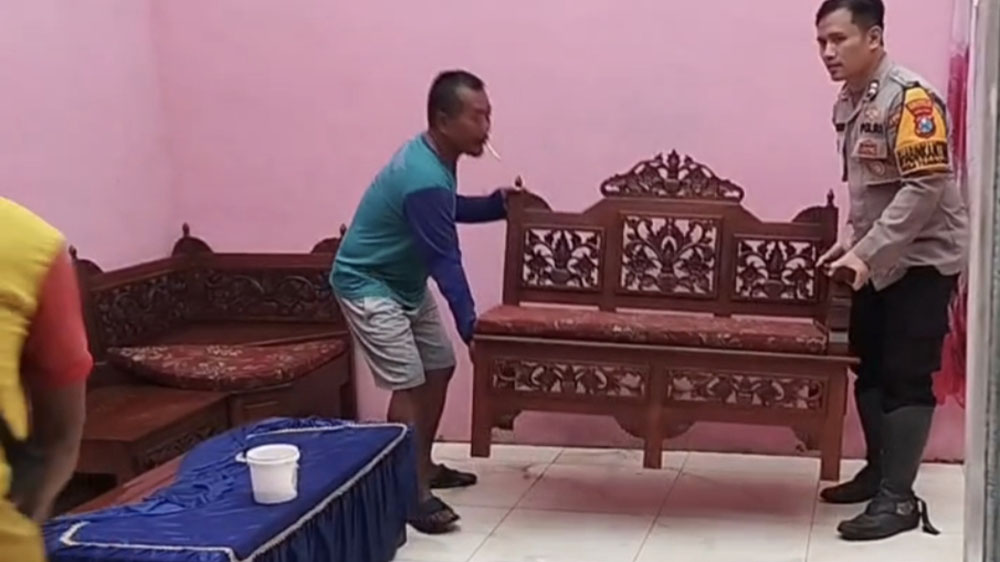 Anggota Polsek Muncar membantu membersihkan rumah korban yang terdampak angin kencang di Dusun Curahpacul, Desa Tambakrejo, Kecamatan Muncar, Sabtu (7/2).
