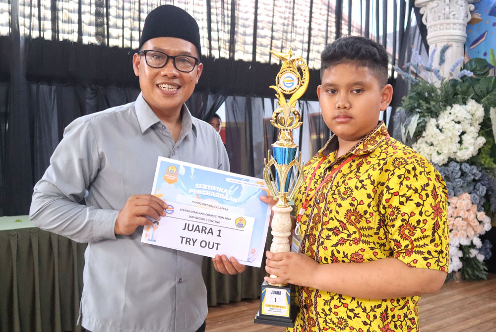 Kepala SMPN 1 Genteng, Ali Mustofa, S.Pd., M.Pd., menyerahkan piala kepada Hafidz Dwi Naufal Afkar pemenang Olimpiade Mipa, dan Try Out dalam SGC 2026, Minggu (8/2).