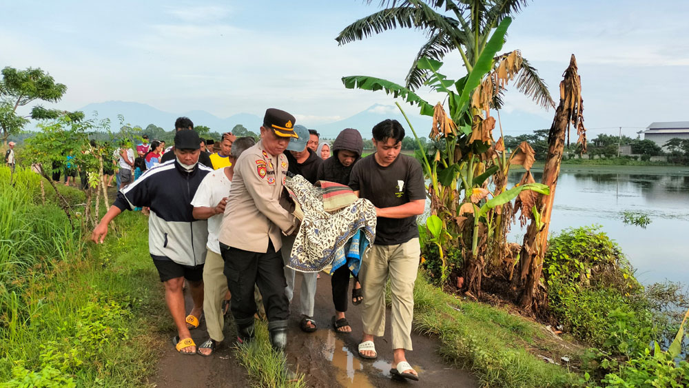 Kapolsek Rogojampi Kompol Imron ikut mengevakuasi jenazah Apris yang tenggelam di bekas galian C, Desa Badean, Kecamatan Blimbingsari, Senin (9/2).
