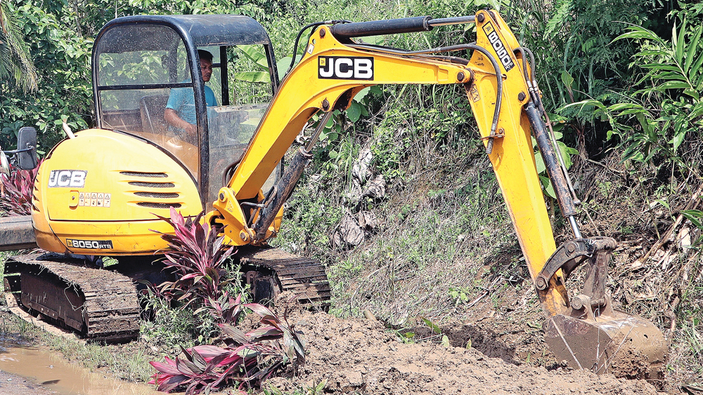 NORMALISASI: Alat berat mengeruk drainase di Dusun Sungailembu, Desa Sumberagung, Kecamatan Pesanggaran, Senin (9/2).