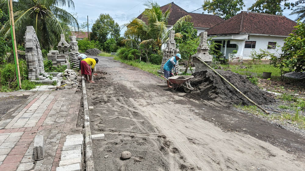 Pavingisasi jalan di Desa Sembulung, Kecamatan Cluring, mulai dikerjakan, Selasa (10/2). Sebelumnya, paving menata paving yang sempat mangkrak tersebut hingga menyerupai candi.