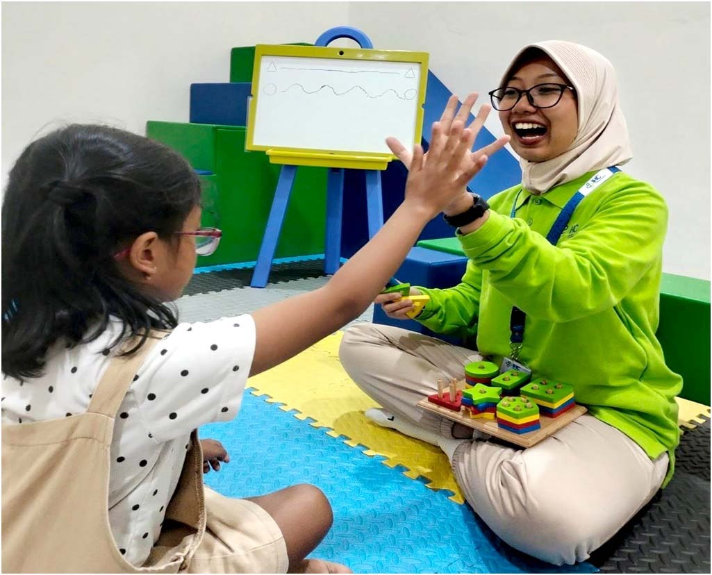 BERSEMANGAT: Terapis Okupasi RSU Bhakti Husada Ria Eka Handayani S.Tr.Kes sedang melakukan tindakan pada anak yang kecanduan gawai.