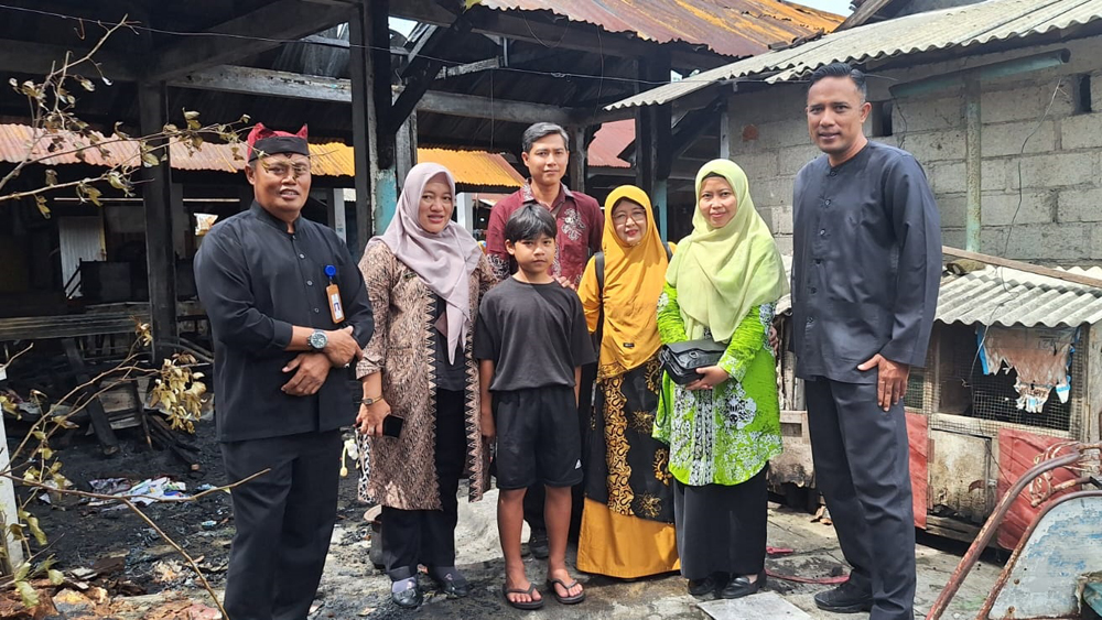 Kepala SDN Kepatihan Suliyantari didampingi Lurah Kepatihan memberikan bantuan kepada siswa yang terdampak kebakaran kios di pasar Tiag Berlian, Senin (10/2).