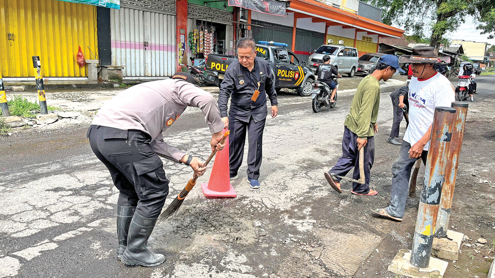 SWADAYA: Jajaran Forpimka menambal jalan berlubang di sejumlah titik rawan kecelakaan di Kecamatan Sempu, Selasa (10/2).