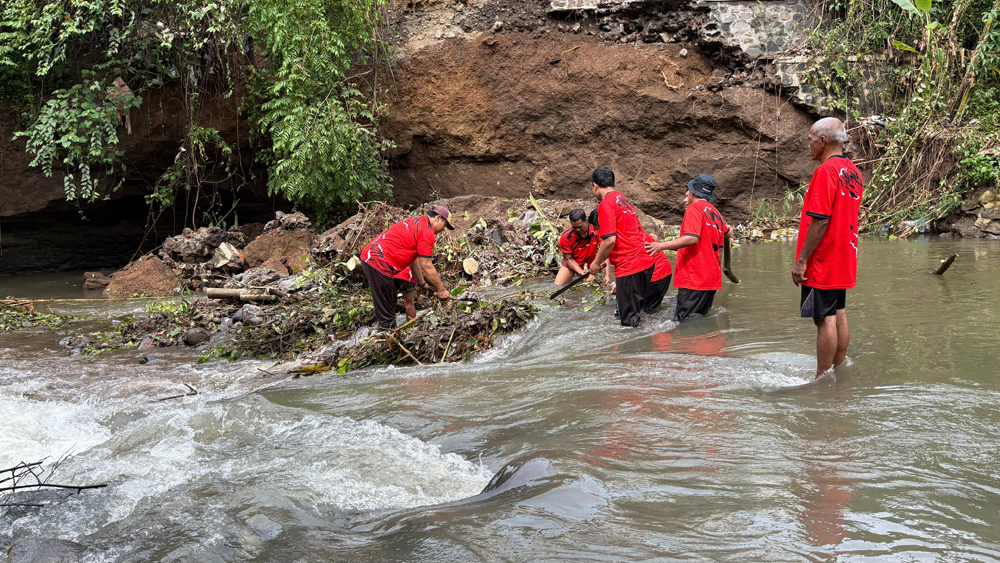Petugas Krosda Singojuruh kerja bakti membersihkan batang, ranting, dan daun pohon yang roboh di aliran sungai Badeng, Desa/Kecamatan Singojuruh, Selasa (10/2).