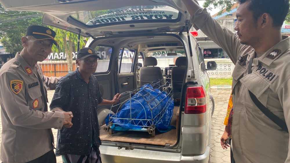 Kapolsek Pesanggaran AKP Maskur (kiri) mengawal jenazah Eko Waluyo yang hendak dibawa menuju rumah duka di Dusun Sumberdadi, Desa Kandangan, Kamis (12/2).