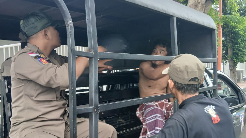Anggota Satpol PP Banyuwangi mengamankan ODGJ yang mengamuk di Jalan Brigjen Katamso, Senin (16/1).