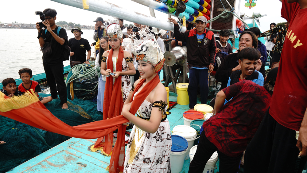 Penampilan penari gandrung di atas perahu nelayan yang hendak berangkat melaut memeriahkan pembukaan Festival Layar Puan Pesisir di Pelabuhan Muncar, Minggu (15/2).