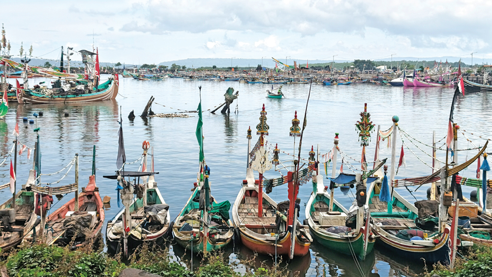 BERJEJER: Perahu nelayan berjejer di Pelabuhan Perikanan Muncar, Selasa (17/2). Imbas cuaca buruk, banyak nelayan yang tidak melaut.