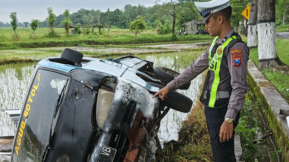 OLAH TKP: Anggota Unit Lantas Polsek Rogojampi sedang menunjukkan salah satu mobil yang terlibat kecelakaan beruntun di Jalan Raya Desa Alasmalang, Singojuruh, Selasa (17/2).