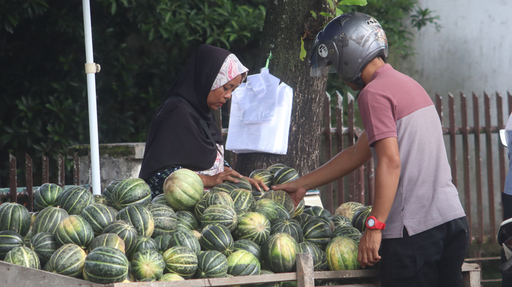 MUSIMAN: Salah satu pedagang blewah melayani pembeli di Jalan Wahid Hasyim, Desa Gentengkulon, Kecamatan Genteng, Kamis (19/2).