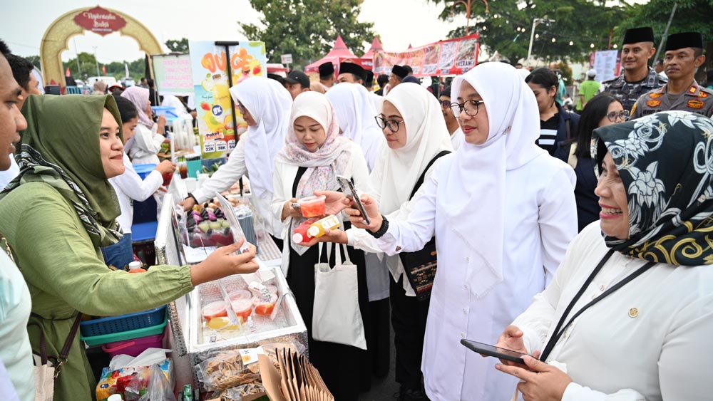 Bupati Ipuk Fiestiandani didampingi Pemimpin Cabang Bank Jatim Banyuwangi Ni Gusti Ayu Putu Sri Lestari membeli takjil di stand Festival Ngerandu Buko di kawasan Marina Boom, petang Kamis (19/2).