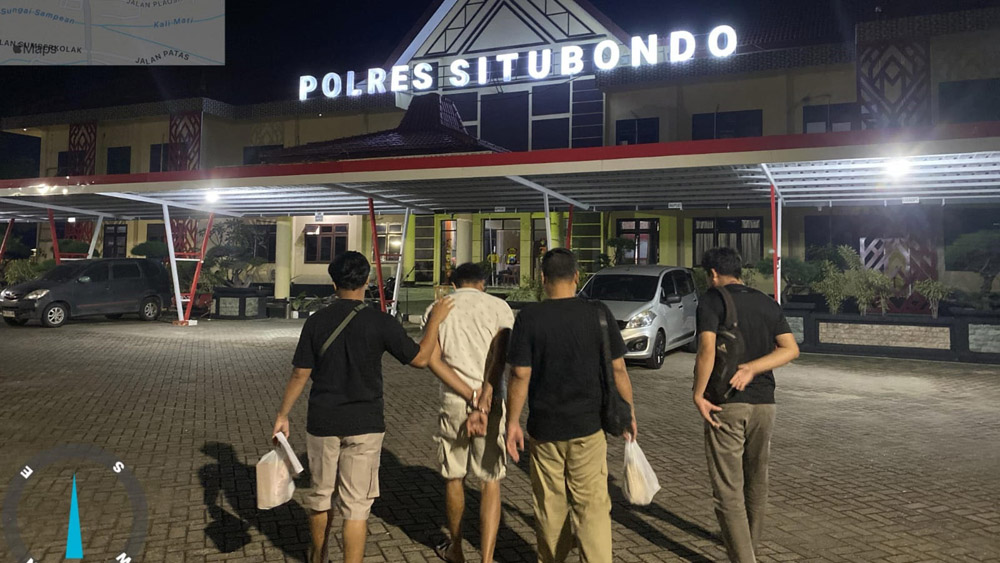 MY, 50, warga Kecamatan Banyuputih, dikeler menuju ruang tahanan Polres Situbondo, Jumat malam (20/2).