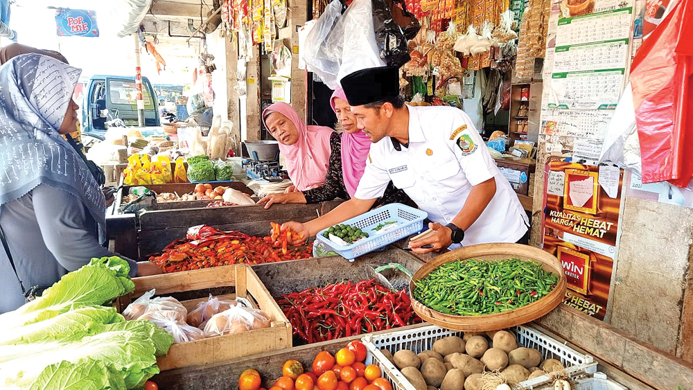 PEDAS: Petugas Pasar Genteng mengecek kondisi cabai yang dijual pedagang pada Jumat (20/2).