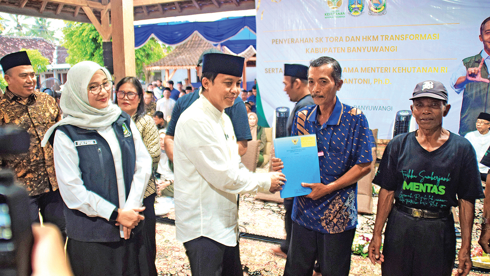 Menteri Kehutanan Raja Juli Antoni didampingi Bupati Ipuk Fiestiandani menyerahkan SK TORA kepada warga di Balai Dusun Sumberjambe, Desa Temurejo, Bangorejo, Sabtu (21/2).