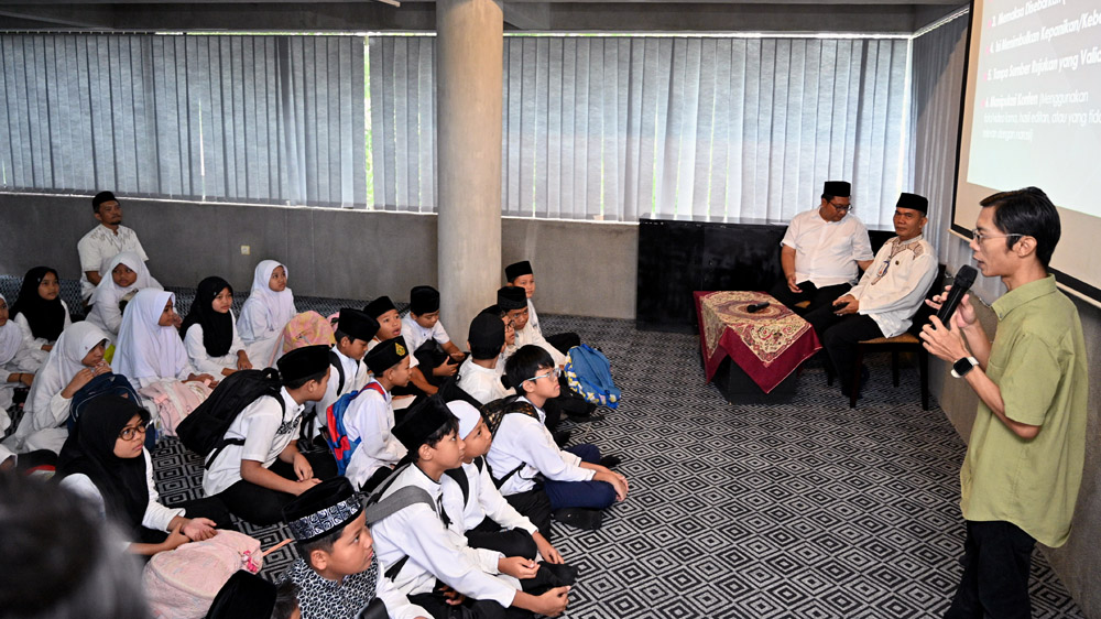 Kepala SDN 4 Penganjuran Dosi Yudha Priangga (kanan) mendampingi para siswa peserta kegiatan Pondok Ramadan di gedung Grha Pena Banyuwangi, Selasa (24/2).