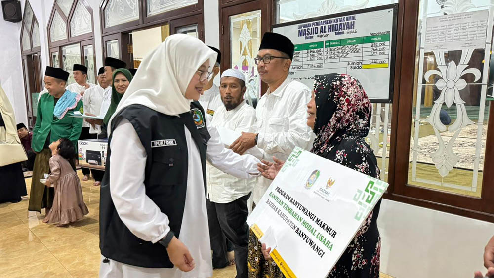 Bupati Ipuk Fiestiandani menyerahkan bantuan tambahan modal usaha dari Baznas kepada Riyati, penjual gorengan di Desa Jajag, Gambiran, Selasa (24/2).