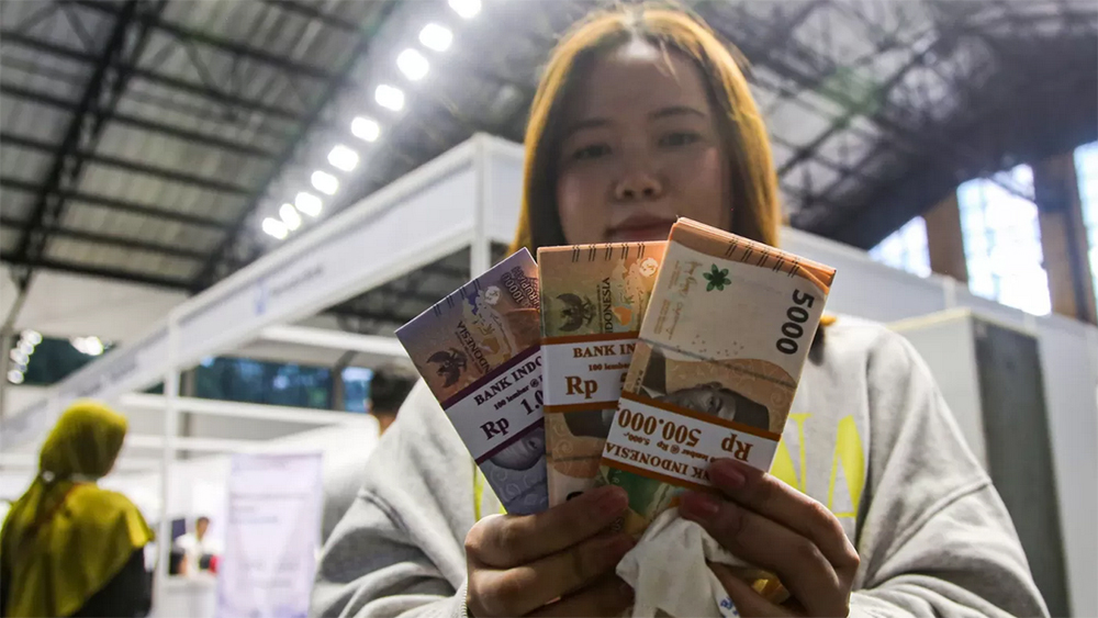 Ilustrasi warga menunjukan uang rupiah usai melakukan penukaran uang baru pada Layanan Penukaran Terpadu Bank Indonesia.