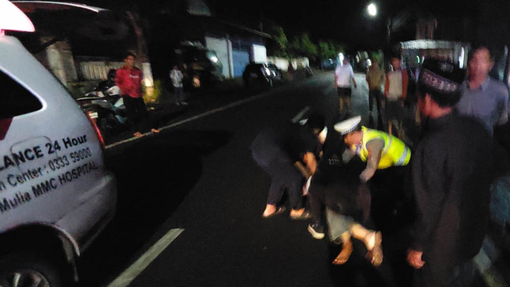 Anggota Unit Lantas Polsek Muncar melakukan olah TKP insiden pemotor jatuh di Jalan Raya Desa Blambangan, Kecamatan Muncar sekitar pukul 23.00 Selasa (24/2).