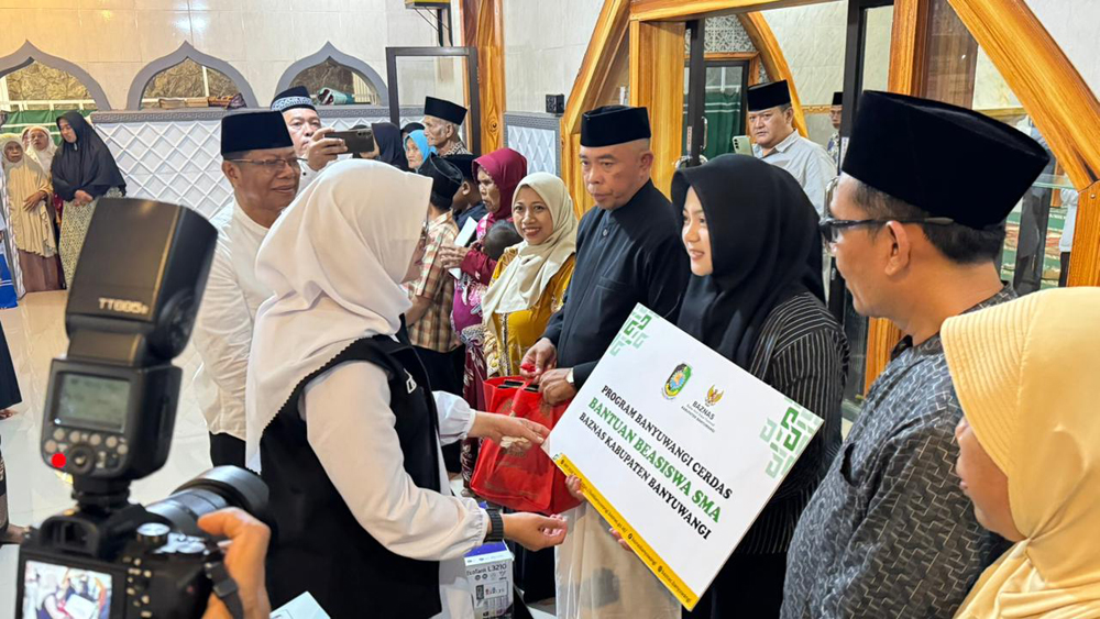 Bupati Banyuwangi Ipuk Fiestiandani menyerahkan bantuan beasiswa kepada Sinta Aulia Putri, siswa SMA Raudaltussalam Glenmore, Rabu (25/2).
