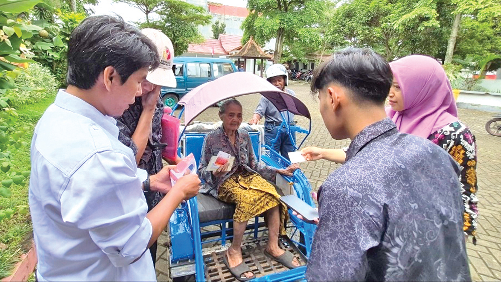 PENERIMA MANFAAT: Petugas PKH Kecamatan Genteng memvalidasi identitas penerima bantuan yang sedang sakit, Kamis (26/2).