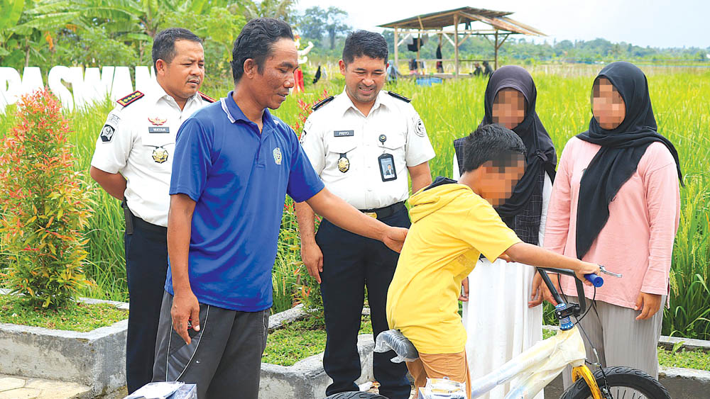 Sejumlah narapidana menyerahkan peralatan sekolah kepada keluarganya di Lahan Sarana Asimilasi dan Edukasi (SAE) Desa Pakistaji, Kecamatan Kabat, Kamis (26/2).