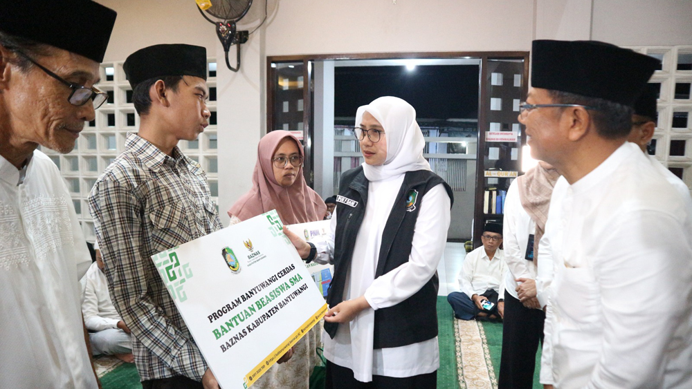 Bupati Ipuk Fiestiandani menyerahkan bantuan beasiswa Baznas kepada Angga Praditha, siswa SMAN 1 Glagah saat safari Ramadan di Masjid Al Fauz Singotrunan, Banyuwangi pada Kamis malam (26/2).