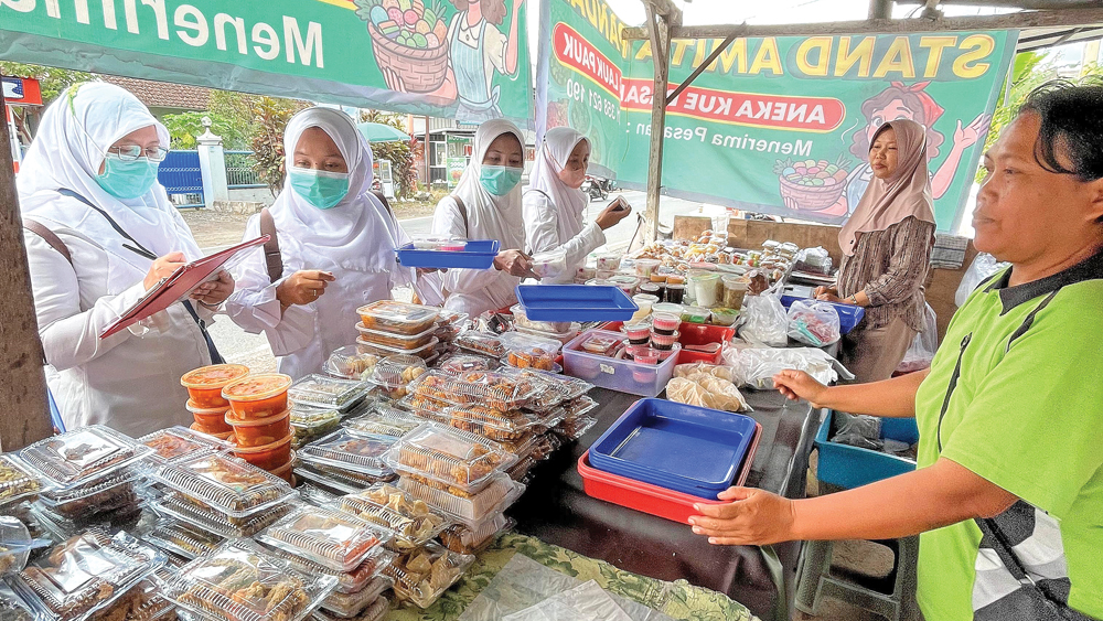 Petugas dari Puskesmas Kembiritan, Kecamatan Genteng, memeriksa makanan takjil yang banyak dijual di sepanjang Jalan Hasanudin, Desa Kembiritan, Jumat (27/2).