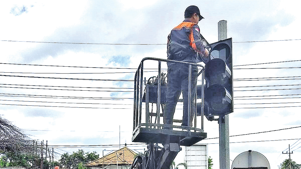 DIBENAHI: Teknisi Dishub membenahi traffic light simpang empat Sukowidi, Kecamatan Kalipuro, Minggu (1/3).