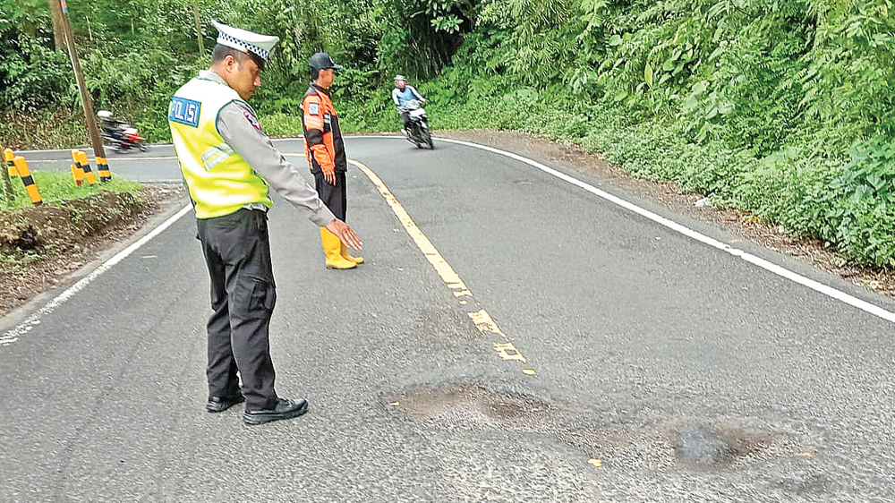 Petugas memetakan titik-titik jalan berlubang di Jalur Gumitir, Dusun Barurejo, Desa Kalibaru Manis, Kecamatan Kalibaru, Senin (2/3).