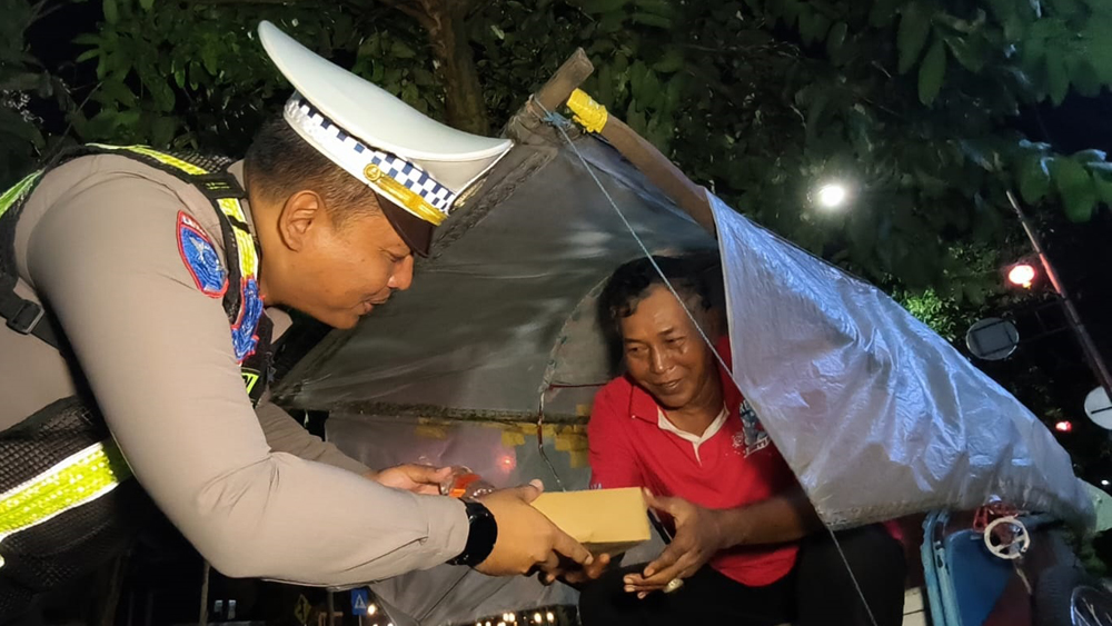 Kanit Turjawali Ipda Rudi membagikan menu sahur kepada abang becak yang mangkal di Jalan Ahmad Yani, Minggu dini hari (1/3).