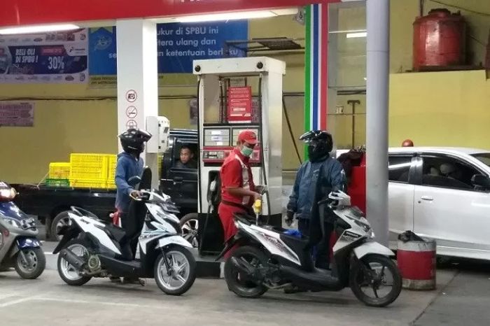 Ilustrasi petugas SPBU Pertamina tengah mengisi BBM pelanggan.