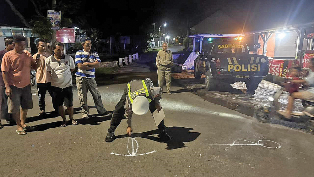 Anggota Kepolisian melakukan oleh tempat kejadian perkara (TKP) tabrakan dua sepeda motor di Jalan Raya Desa Kebondalem, Kecamatan Bangorejo pada Jumat malam (27/2).